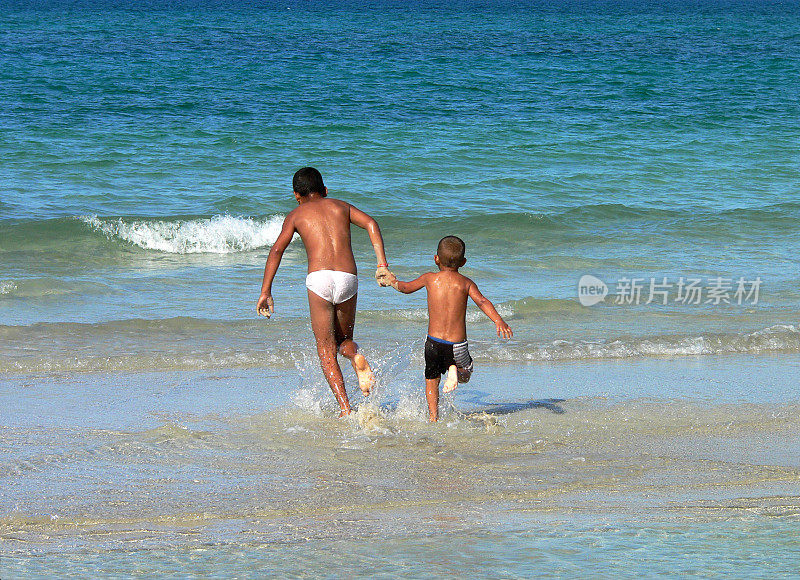 两个古巴男孩跑进水里