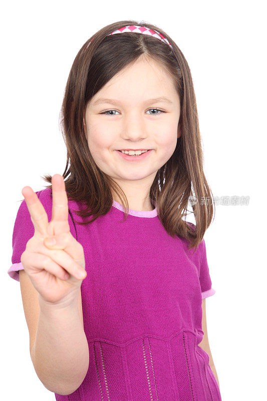 身穿紫色连衣裙、面带微笑的年轻女孩做着和平的手势。