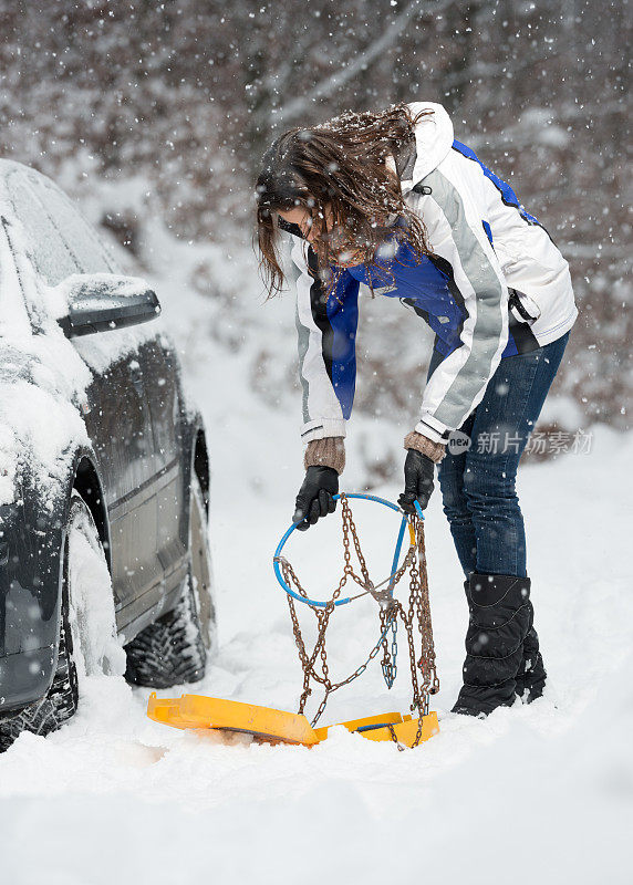 被困在暴风雪中，女人使用雪链