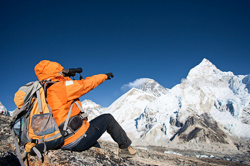 用双筒望远镜看珠穆朗玛峰的女人