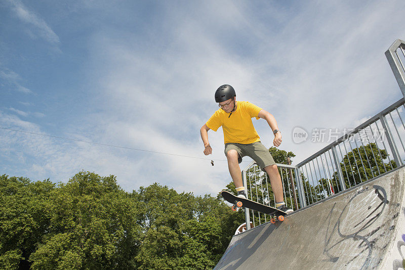一个小男孩在滑板公园的斜坡上玩滑板