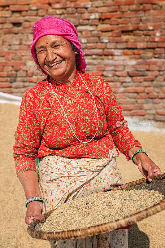一名正在筛米的尼泊尔妇女