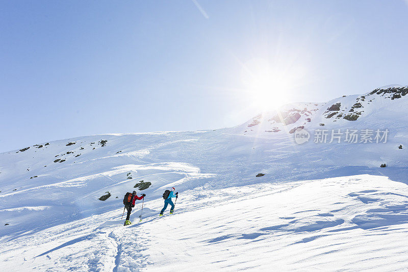 一对高山滑雪夫妇登上山顶