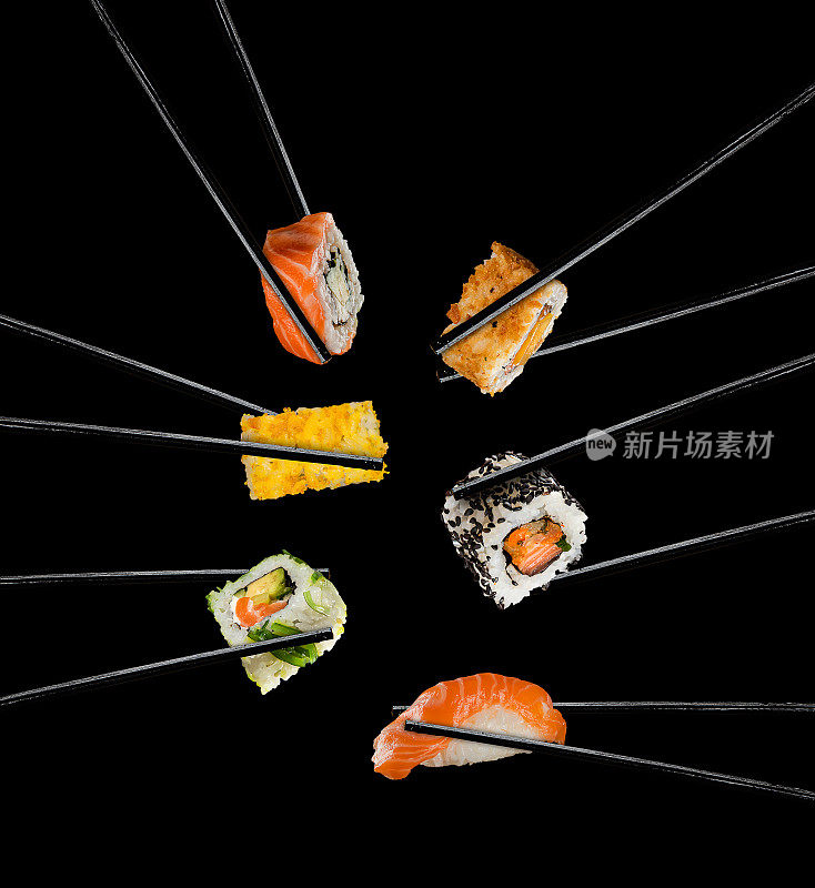 寿司夹在筷子之间，以黑色为背景