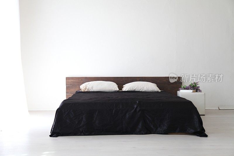 室内白色的卧室和黑色床单的床
