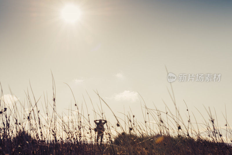 男人在秋日的阳光下徒步旅行。