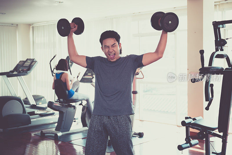 英俊的男人在健身房锻炼。用新一代的生活方式保持健康。