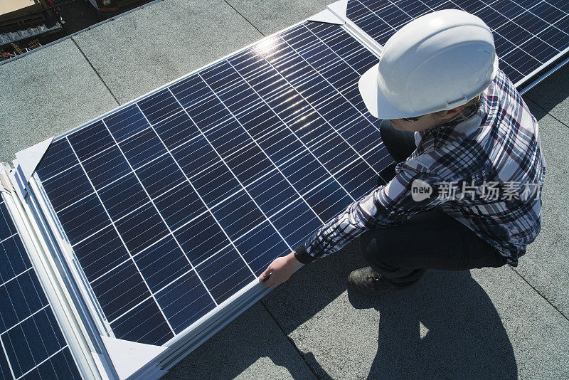 女建筑工人正在安装太阳能电池板