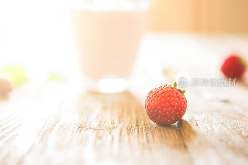 草莓特写放在质朴的木桌上，配上酸奶