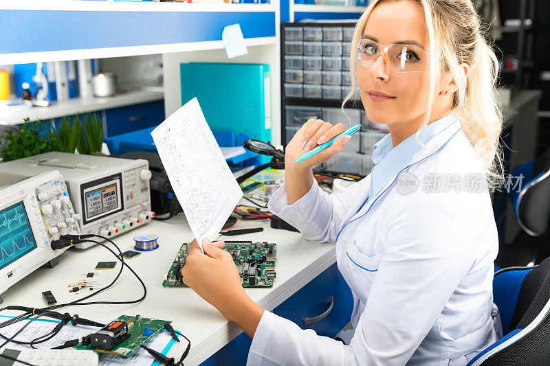 女电子工程师在实验室检查电子电路