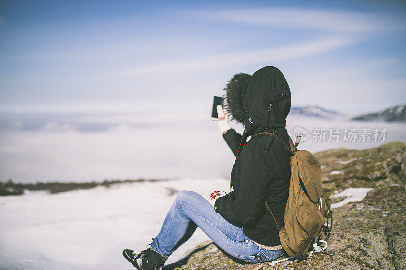 女孩在户外的山峰上发短信。