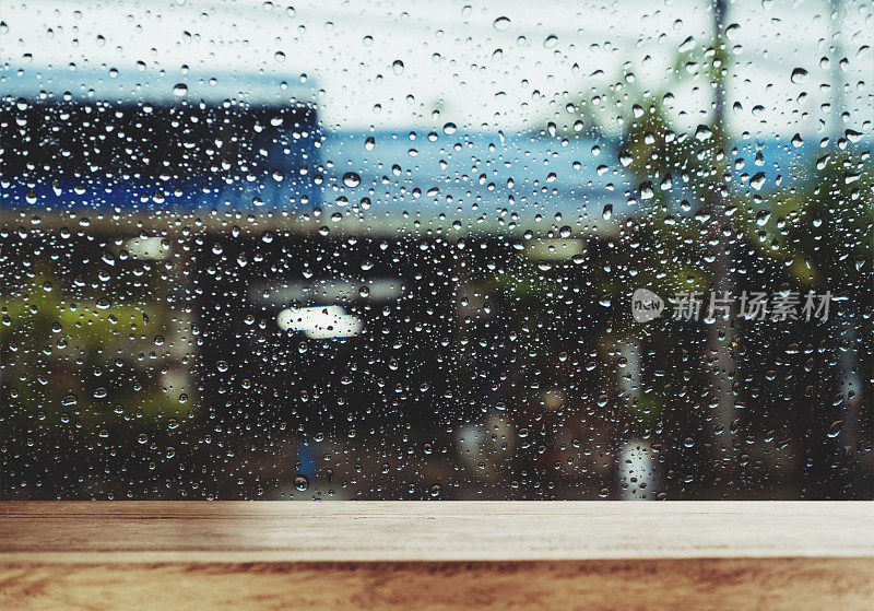 雨天的窗户上有雨滴的木头桌子，作为背景