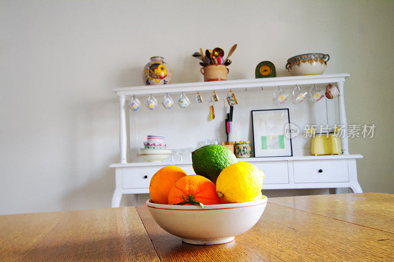 木餐桌上的水果盘;餐具柜在后台