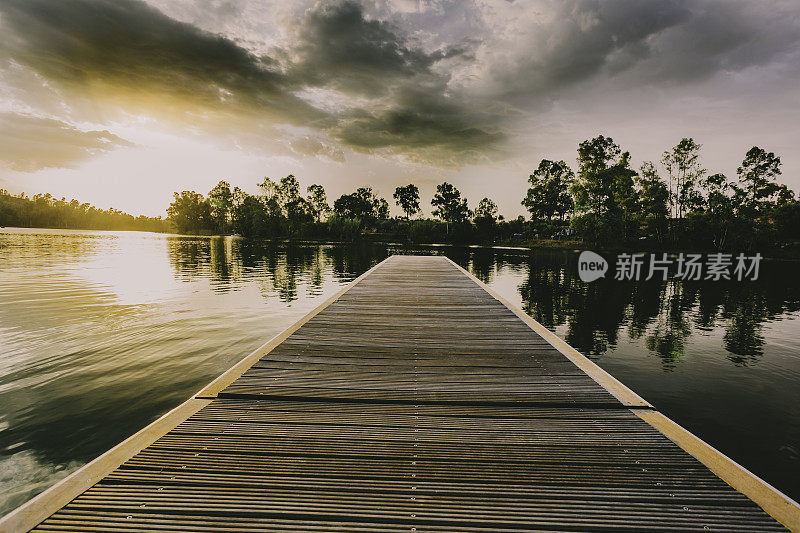 木防波堤在湖上日落在天空与云彩