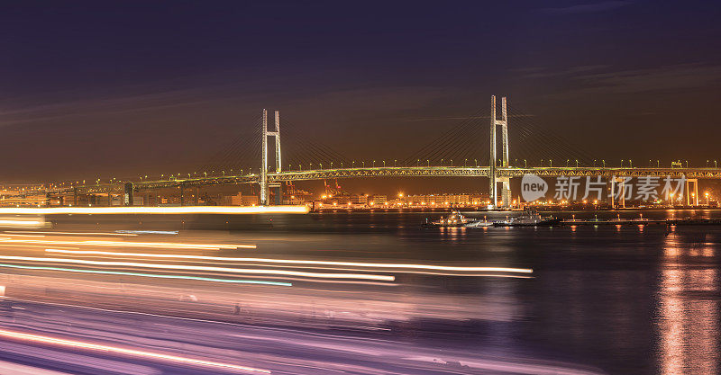 横滨港区三桥码头的横滨海湾大桥全景图，在夜晚的天空下，有船只的航速灯。