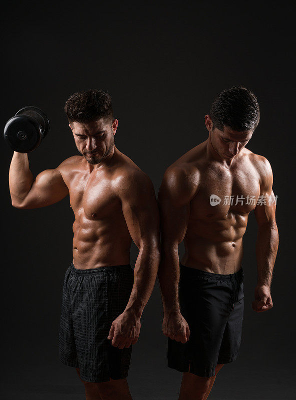 两个强壮的肌肉男看着摄像机