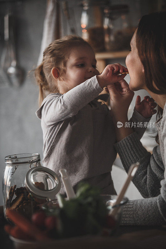 小女孩在喂她妈妈饼干