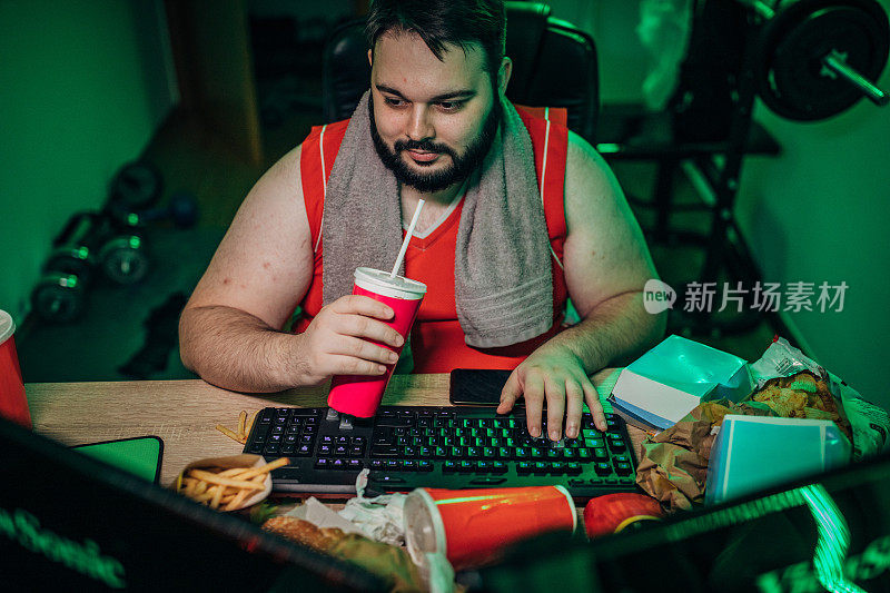胖男人在家里玩电脑游戏