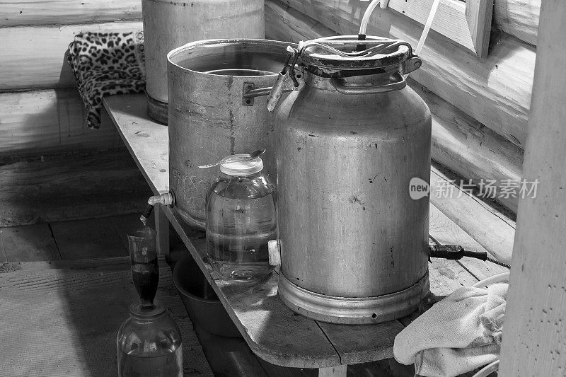 在一个村庄的浴室里用原始的私酿烈酒蒸馏器准备私酿烈酒的过程。