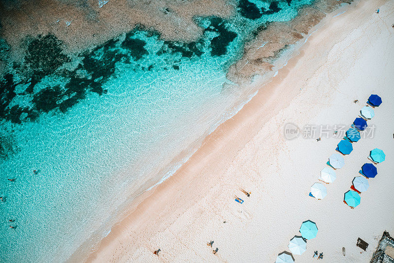 海滩伞和蓝色的海洋。从上面看海滩景色