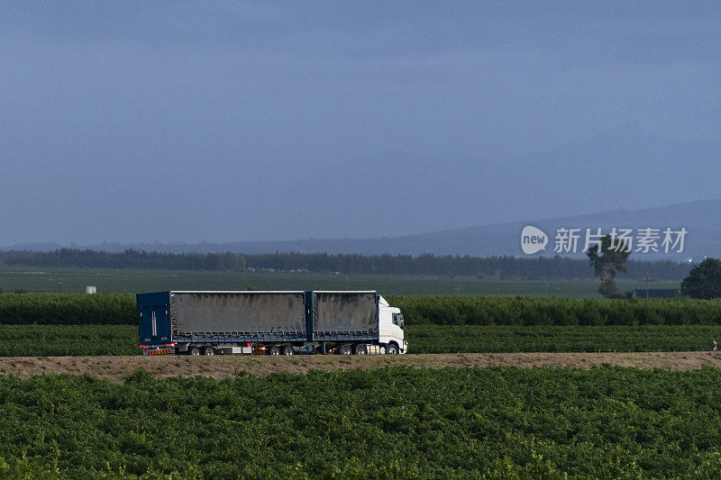 一辆蓝色卡车行驶在南非葡萄酒产区的高速公路上