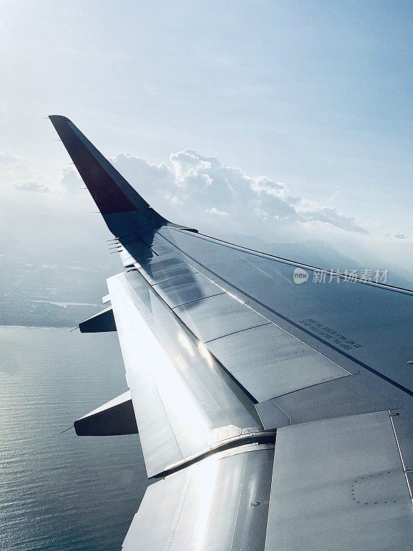 飞机机翼在天空中飞行与海洋和天空的背景