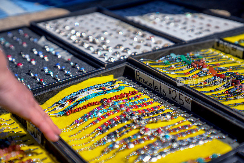 年轻的纳瓦霍人在犹他州沙漠的路边小摊上向顾客出售正宗的珠宝