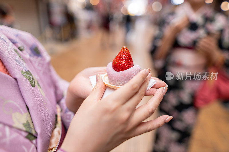 穿着和服的年轻女子手持“一护大福”——日本甜食