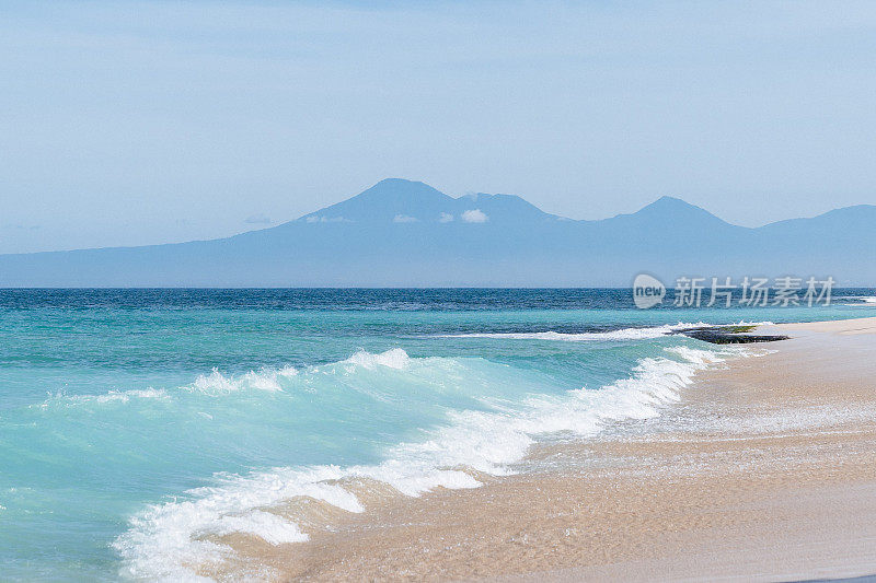 巴厘岛海滩景色-碧绿的印度洋，山脉和蓝天在背景