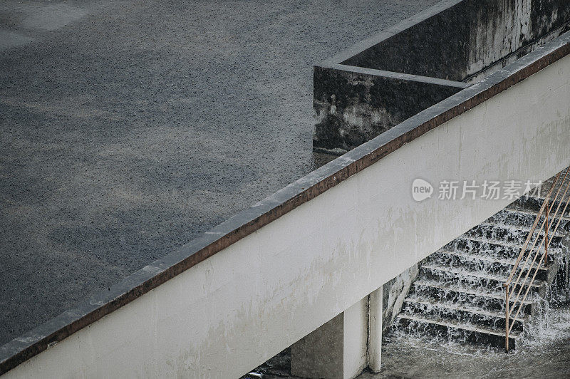 室外大雨滂沱，水顺着楼梯往下流