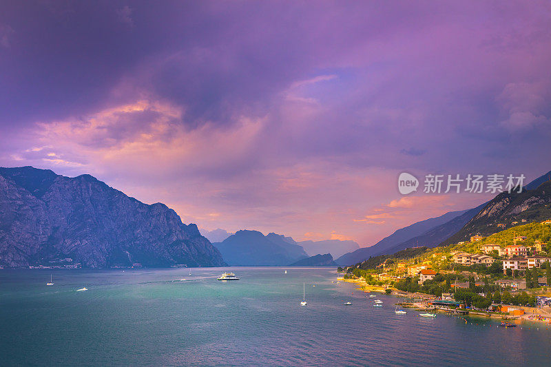 日落时分，绿松石色的加尔达湖和上面的帆船——马尔切辛，伦巴第，意大利