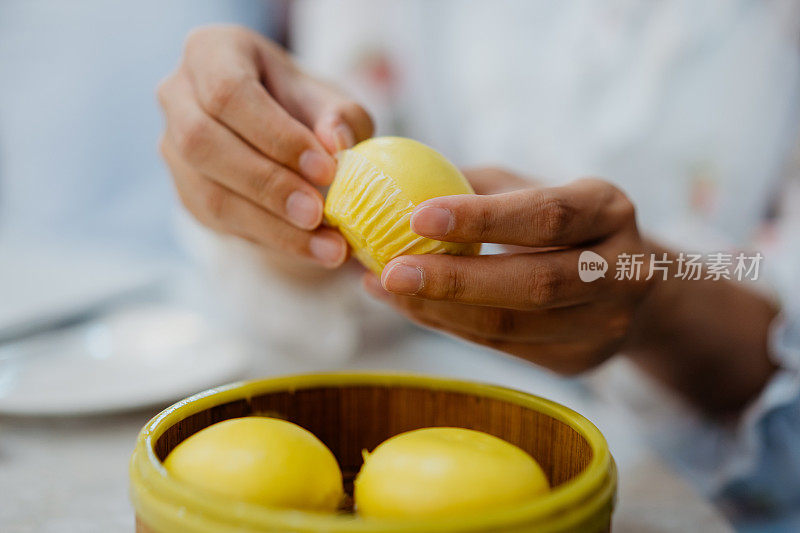 年轻的中国女人在点心餐厅享用馒头