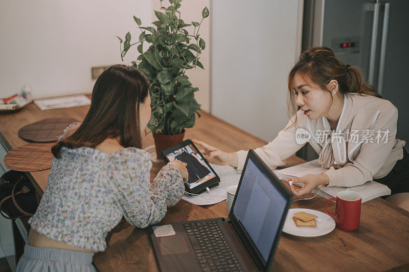 一个亚洲的中国漂亮女人在厨房工作和网上购物周末