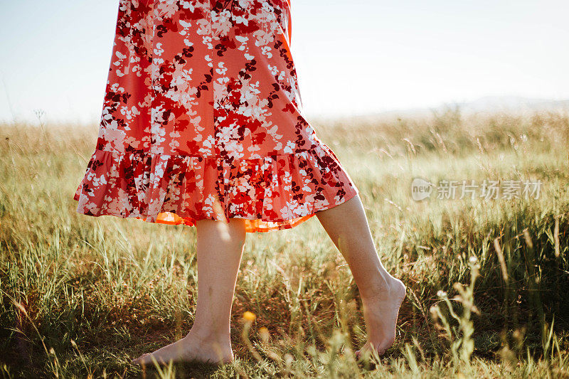 一个光着脚的女人走过草地