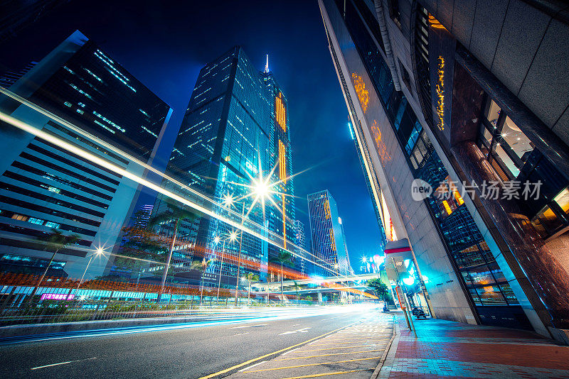 霓虹夜路，高速公路，高速交通穿过摩天大楼的城市景观香港