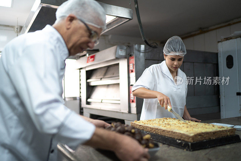 两名厨师在一间商业厨房里布置甜点