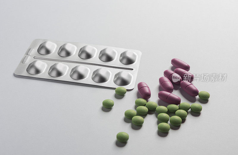 绿色和粉红色的药片和药片在白色的背景