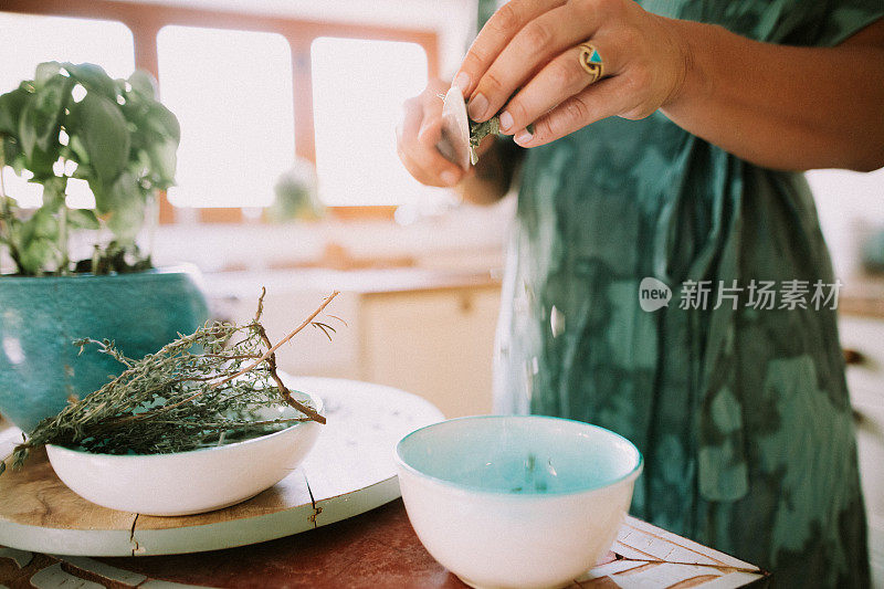 一个女人在厨房里割花园里的香草