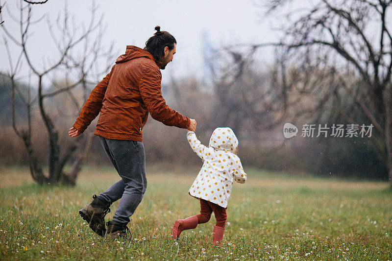 父亲和女儿在雨中漫步