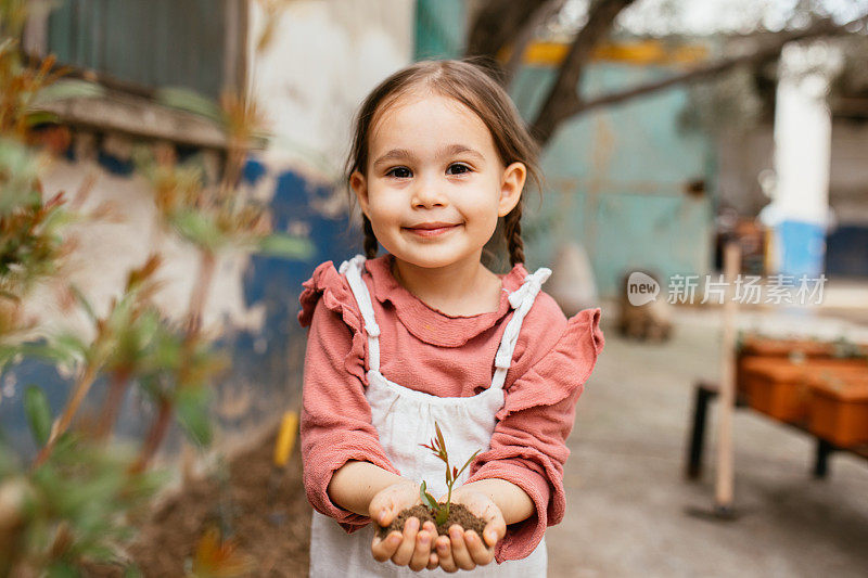 孩子们照料着幼苗。手扶小树