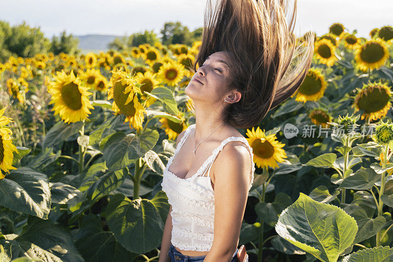 青少年的精神。年轻的少女在向日葵的中间在夏天。旅行和享受。生态旅游。