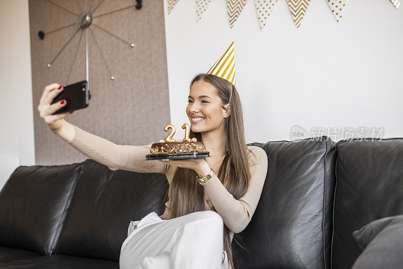 一个漂亮的女人在家里用巧克力蛋糕庆祝她21岁生日的时候视频通话