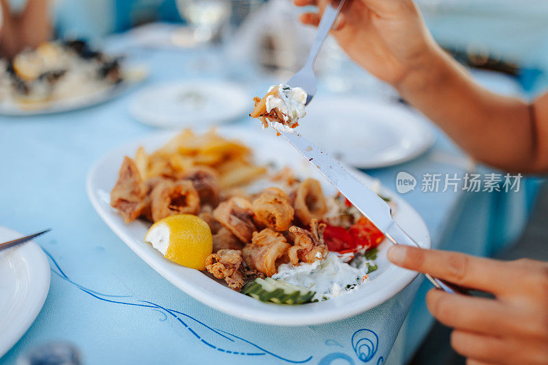 年轻女子在户外餐厅吃海鲜午餐