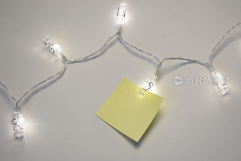 圣诞节庆祝信息的概念。用圣诞灯挂便条纸
