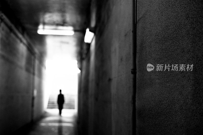 一个人走在隧道里，黑白