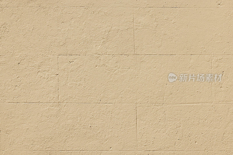 旧的新粉刷的米色混凝土墙的一部分