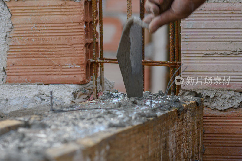 砌砖工在墙体结构中调整水泥