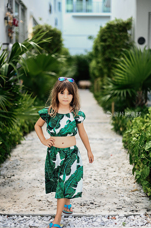 活泼时髦的小女孩穿着热带露脐上衣与度假氛围在迈阿密闲逛