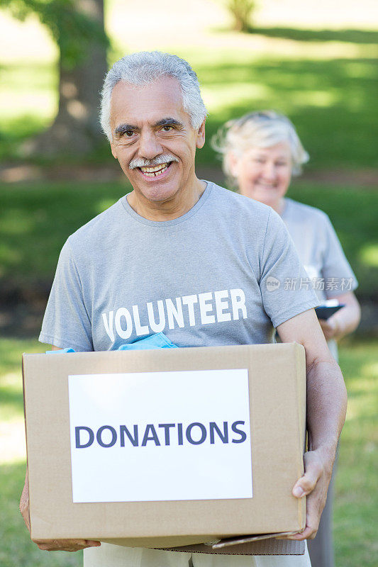 快乐志愿者老人家捧着捐款箱