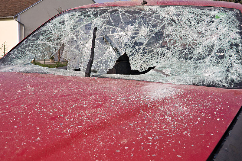 一辆挡风玻璃破碎的红色汽车